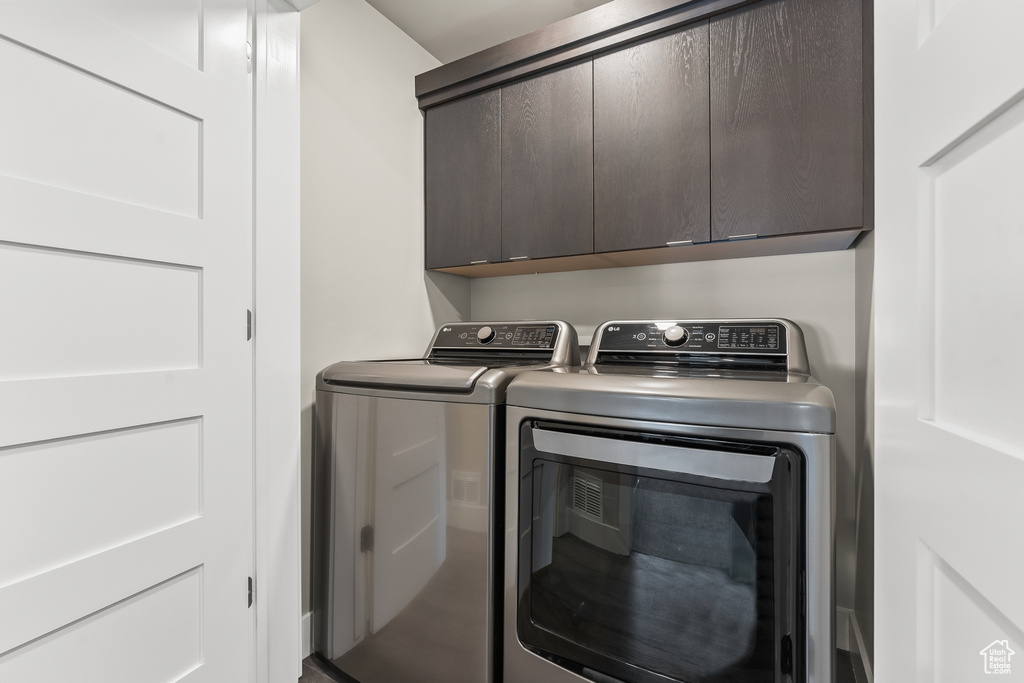 Laundry area featuring cabinets and washer and clothes dryer