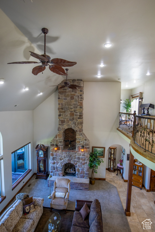 Tiled living room featuring a stone fireplace and ceiling fan