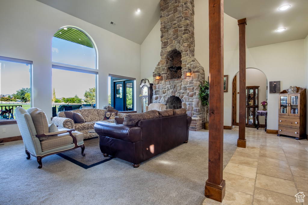 Carpeted living room with a fireplace and high vaulted ceiling