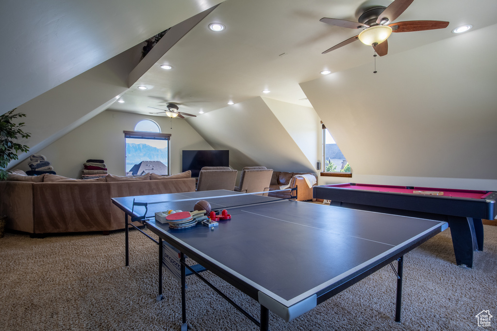 Recreation room featuring lofted ceiling, light carpet, and ceiling fan