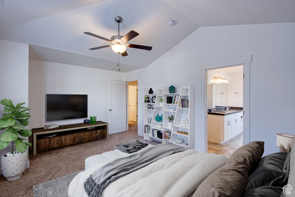Bedroom with light colored carpet, lofted ceiling, ensuite bath, and ceiling fan