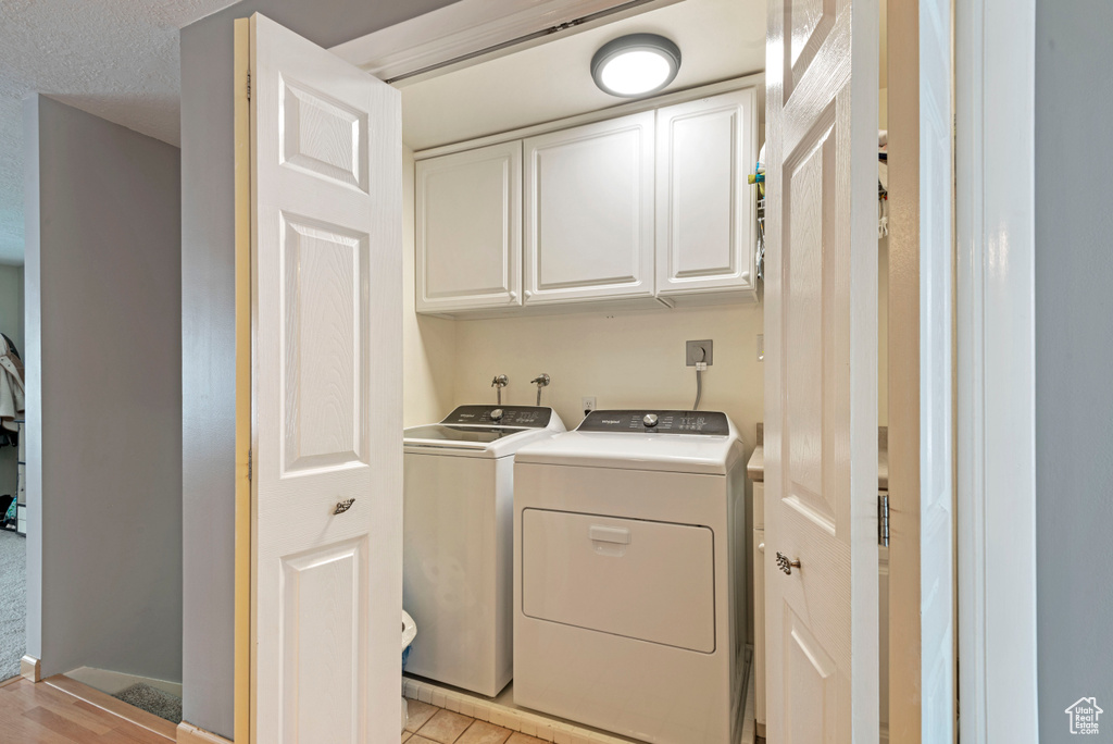 Washroom featuring cabinets, washing machine and dryer, and hookup for an electric dryer