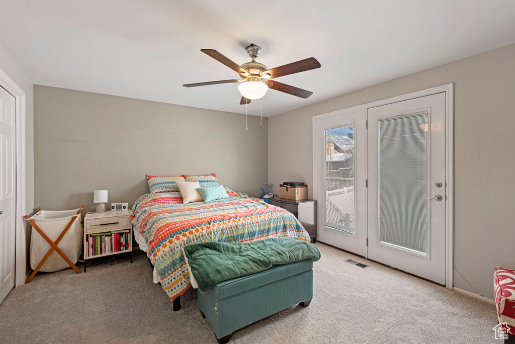 Carpeted bedroom with access to outside and ceiling fan