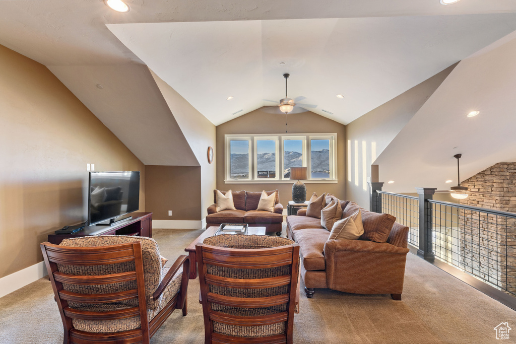 Living room featuring vaulted ceiling, light carpet, and ceiling fan