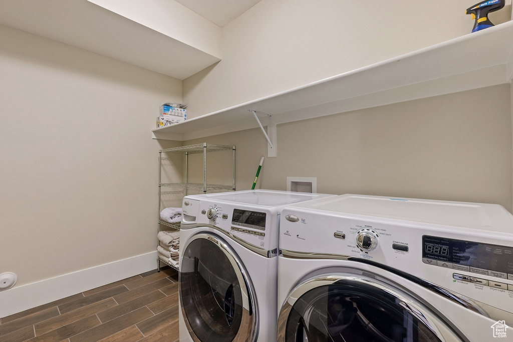 Laundry area with dark hardwood / wood-style floors and separate washer and dryer
