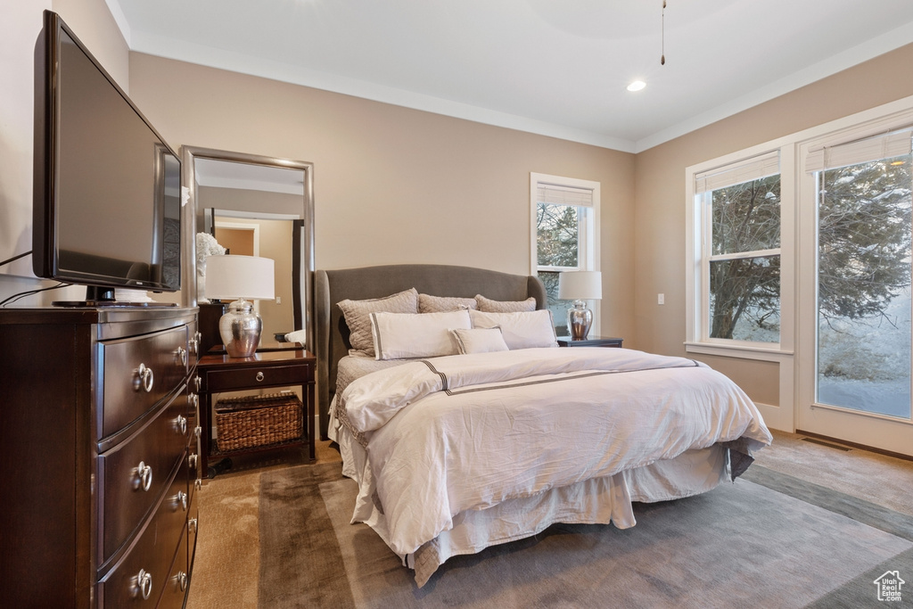 Carpeted bedroom with access to outside and ornamental molding