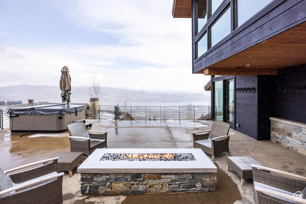 View of patio with a mountain view and a fire pit