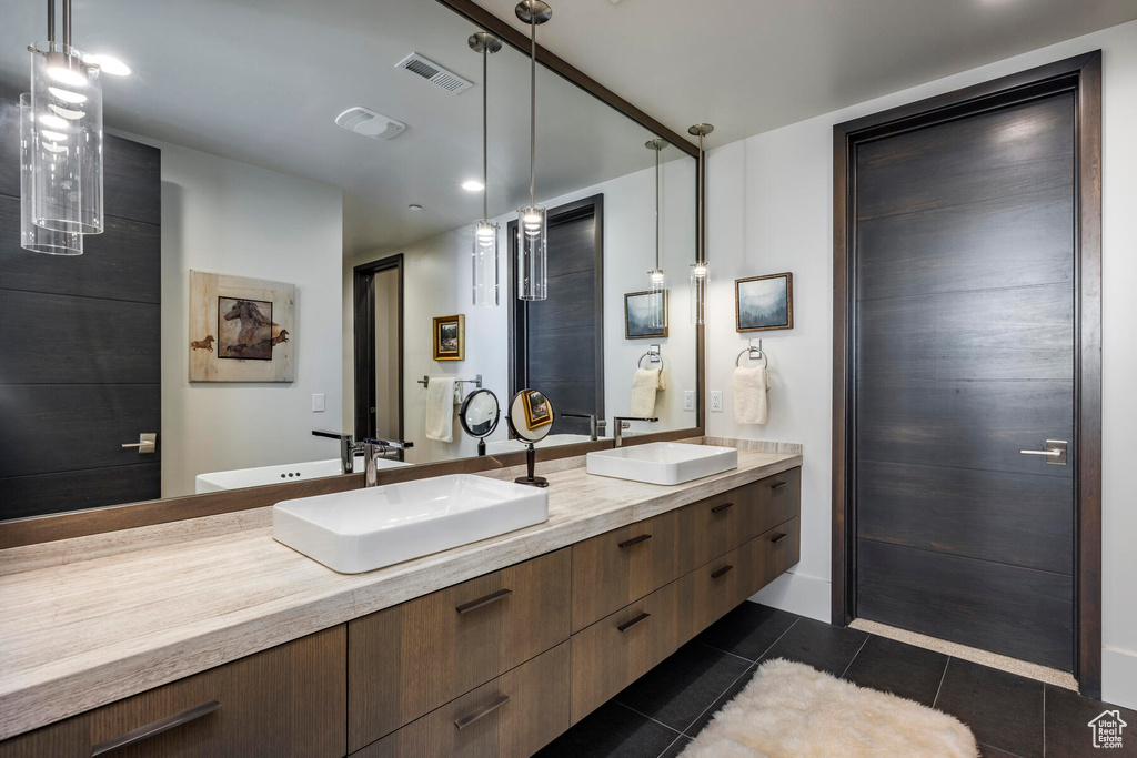 Bathroom with large vanity, tile floors, and dual sinks