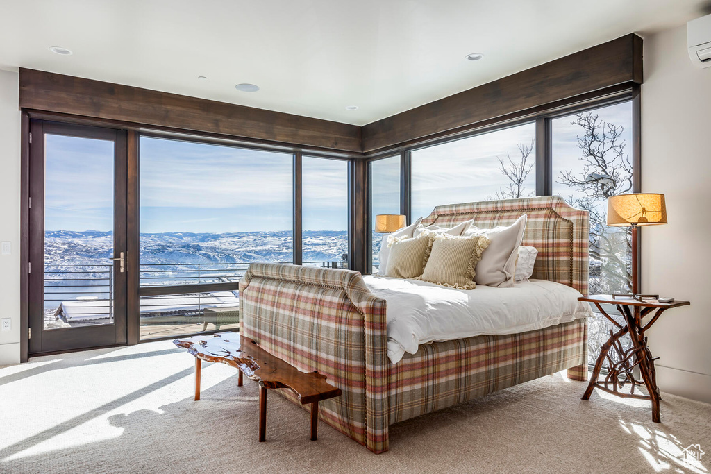 Carpeted bedroom featuring a wall mounted air conditioner, a mountain view, and multiple windows
