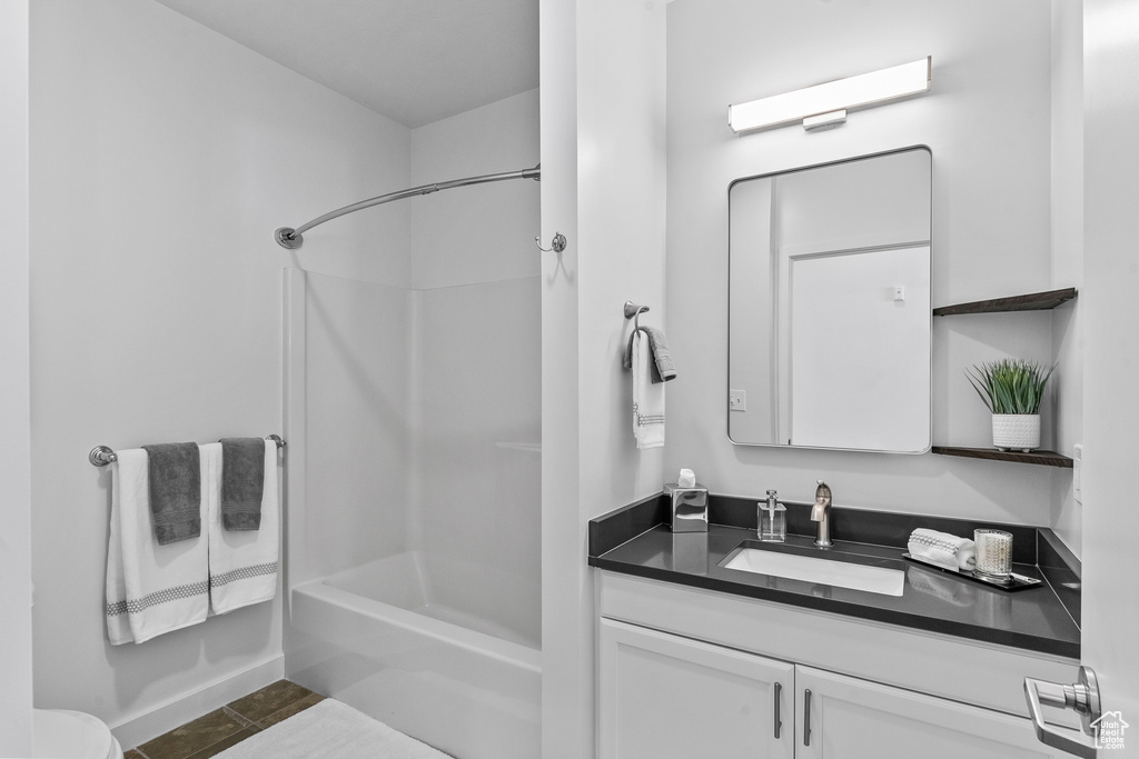 Full bathroom with vanity, toilet, tub / shower combination, and tile floors