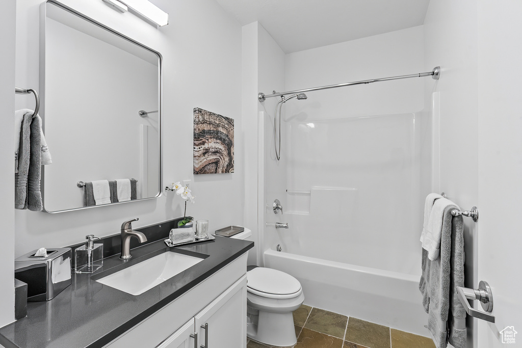Full bathroom featuring shower / washtub combination, vanity with extensive cabinet space, tile floors, and toilet
