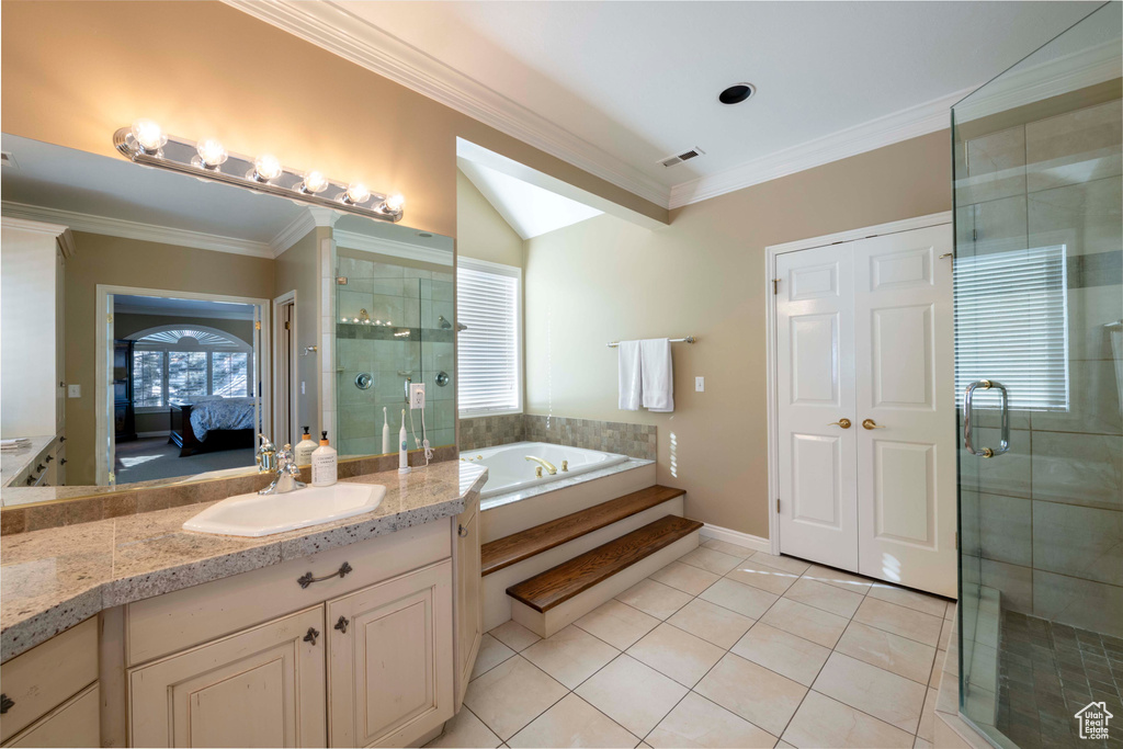 Bathroom featuring ornamental molding, tile floors, large vanity, and independent shower and bath