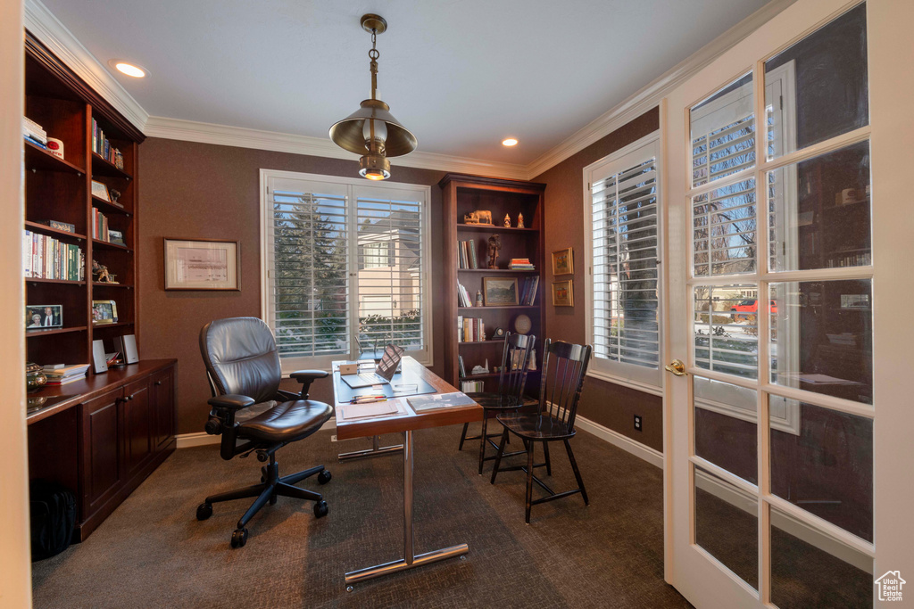 Home office featuring ornamental molding, dark carpet, built in shelves, and french doors