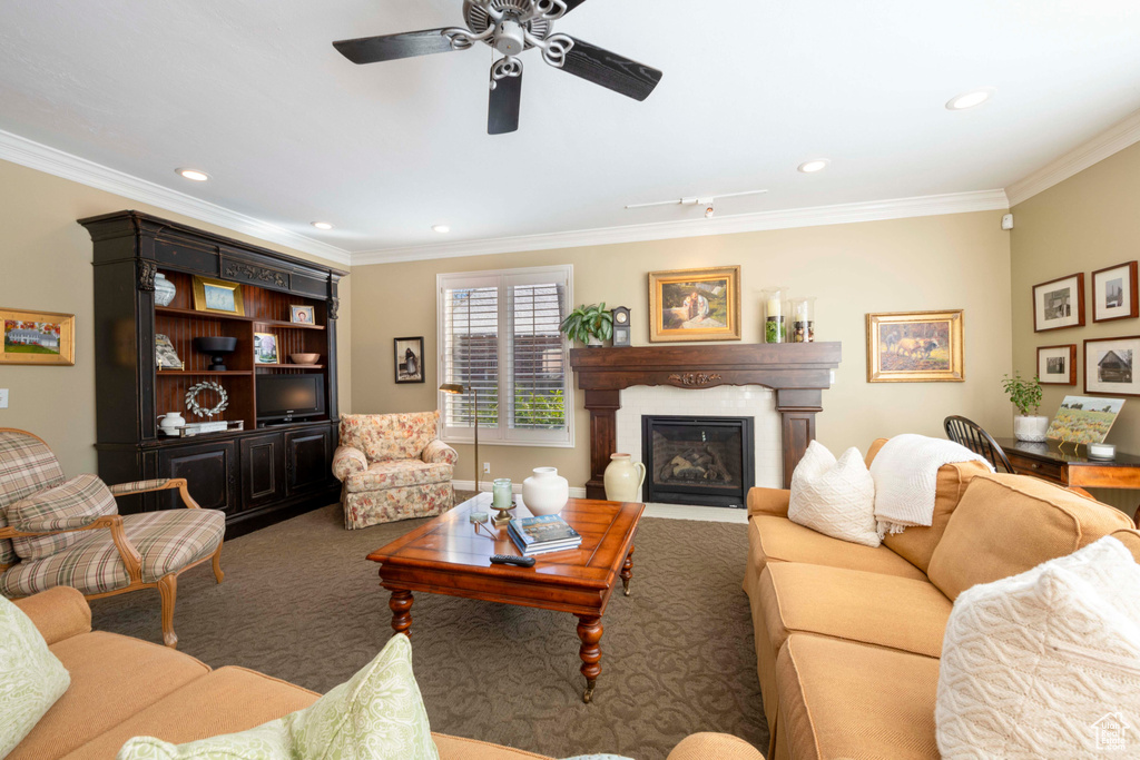 Carpeted living room featuring crown molding and ceiling fan