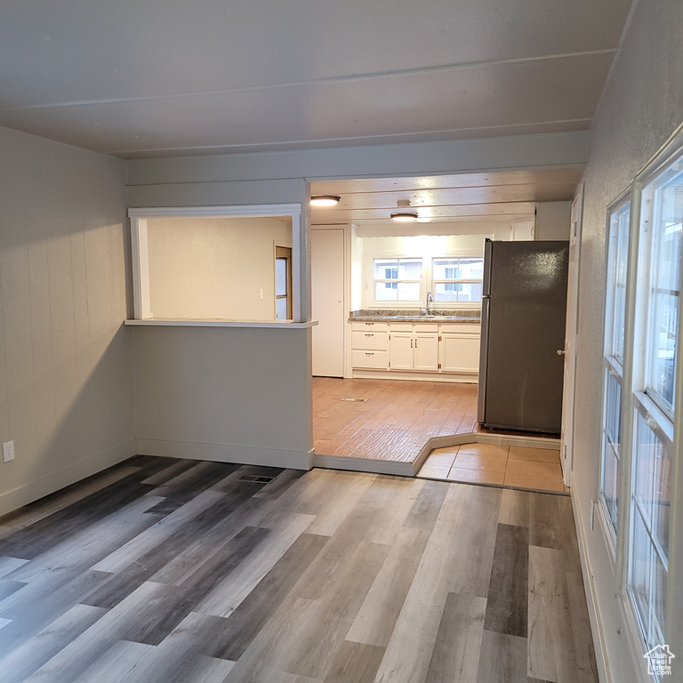 Interior space with sink, black fridge, and light hardwood / wood-style floors