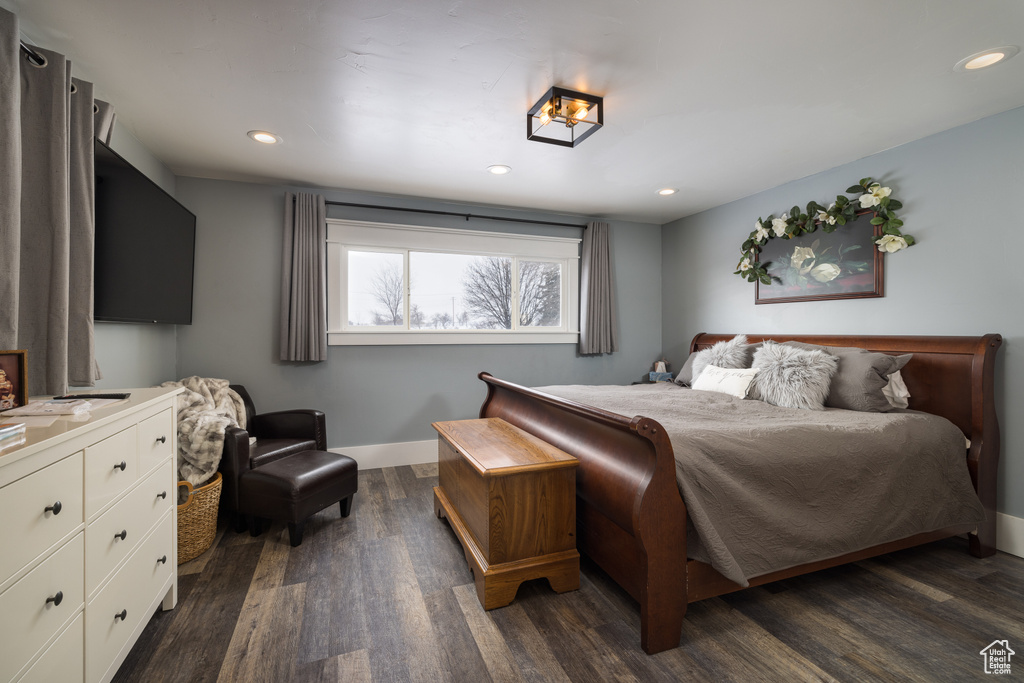 Bedroom with a notable chandelier and dark hardwood / wood-style floors
