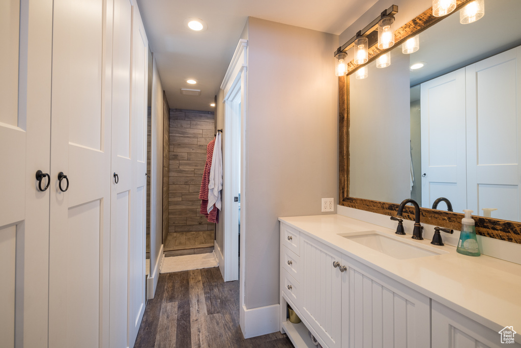 Bathroom featuring vanity, walk in shower, and hardwood / wood-style flooring