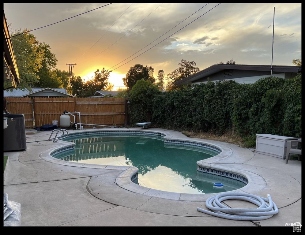 Pool at dusk featuring central AC unit