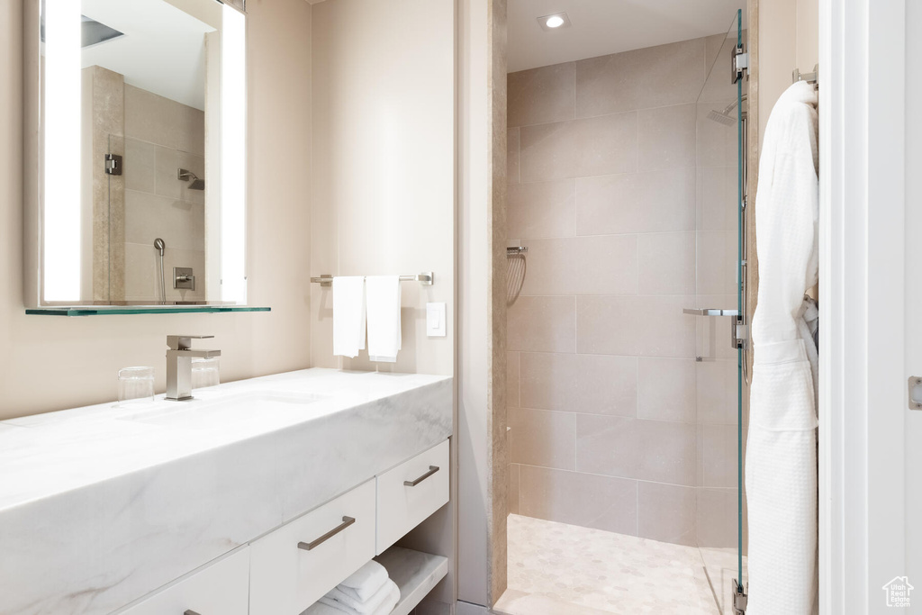 Bathroom featuring an enclosed shower and vanity with extensive cabinet space