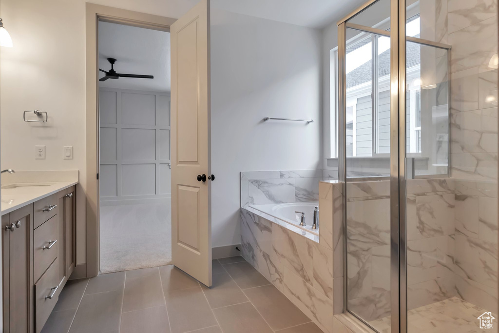 Bathroom with tile flooring, vanity, plus walk in shower, and ceiling fan