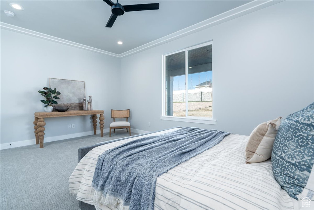 Carpeted bedroom with crown molding and ceiling fan