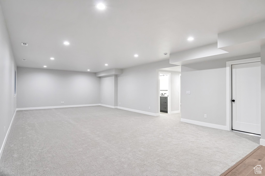 Basement featuring light carpet