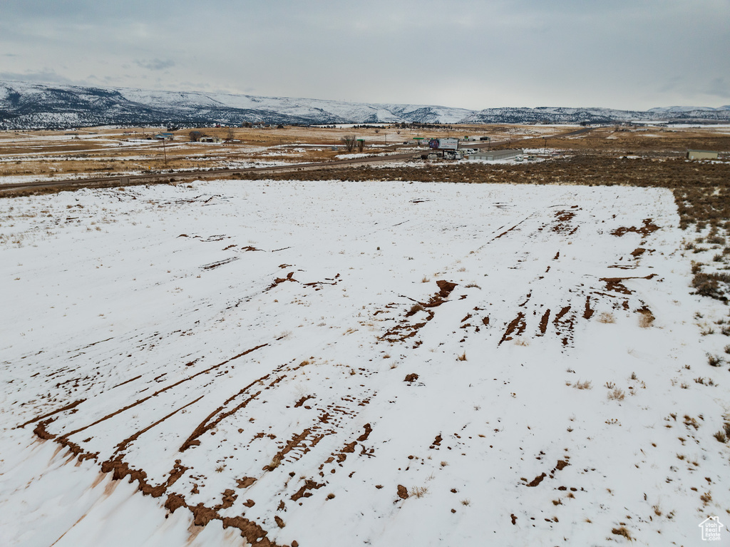 Snowy aerial view featuring a rural view and a mountain view