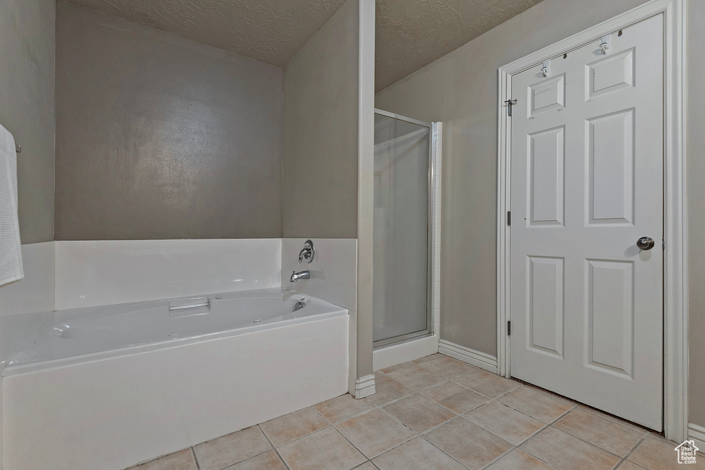 Bathroom with tile floors, plus walk in shower, and a textured ceiling
