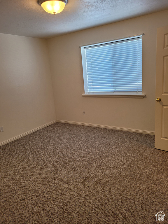 Unfurnished room featuring dark carpet