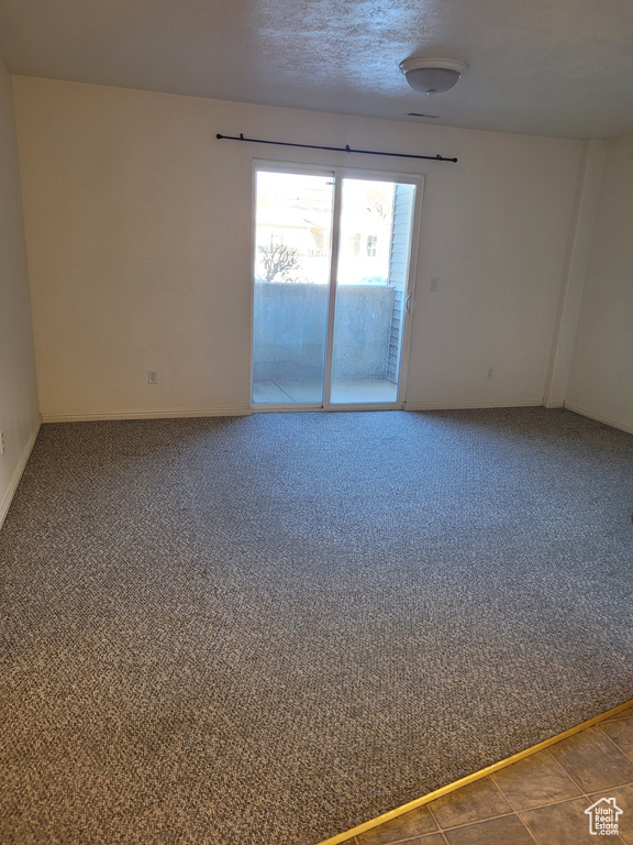 Unfurnished room featuring carpet flooring and a textured ceiling