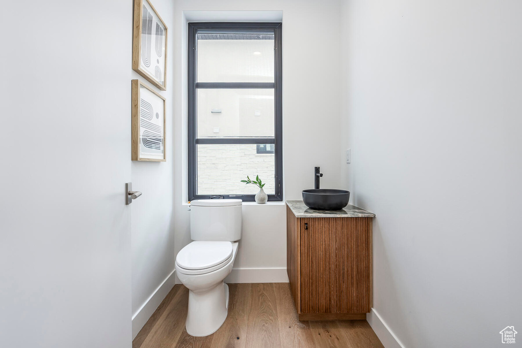Bathroom with toilet, vanity, and hardwood / wood-style flooring