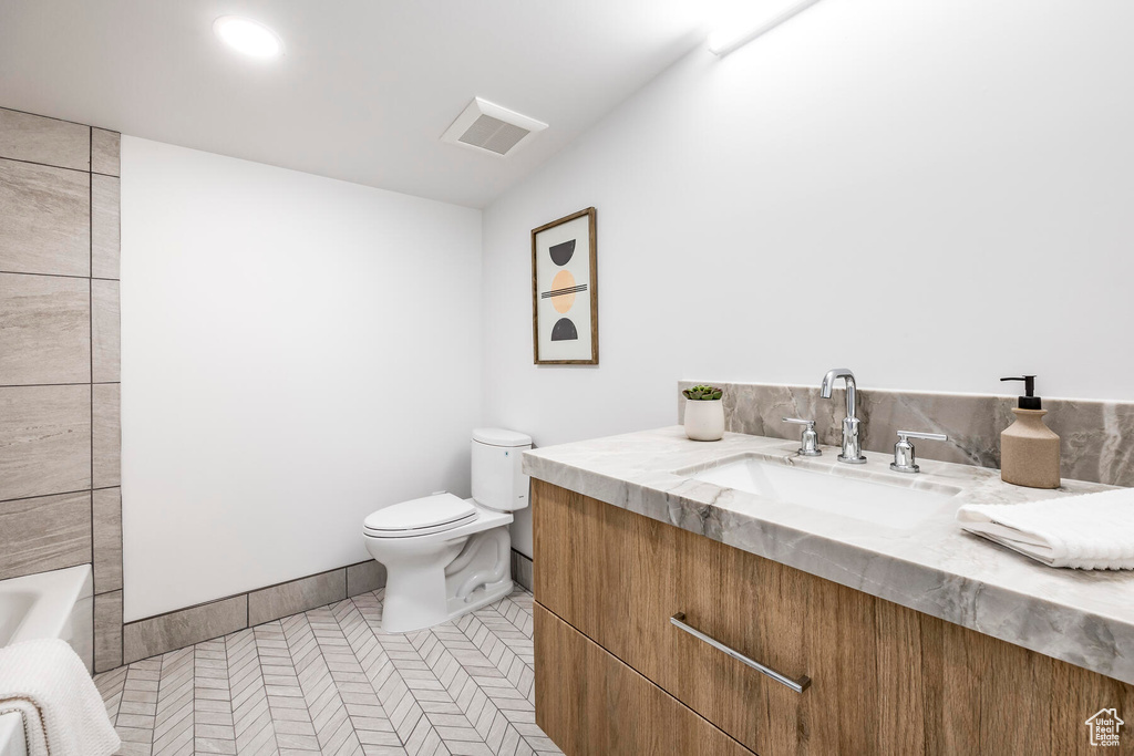 Full bathroom featuring vanity, toilet, tile flooring, and bathing tub / shower combination