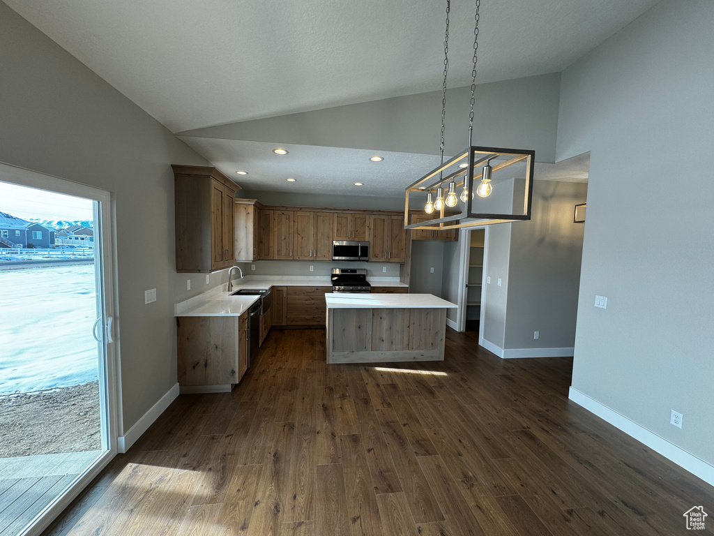 Kitchen featuring dark hardwood / wood-style flooring, a notable chandelier, decorative light fixtures, electric range, and a center island