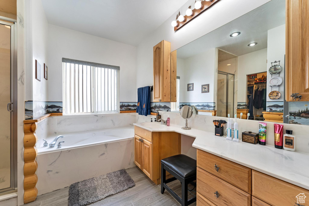 Bathroom with hardwood / wood-style floors, plus walk in shower, and oversized vanity