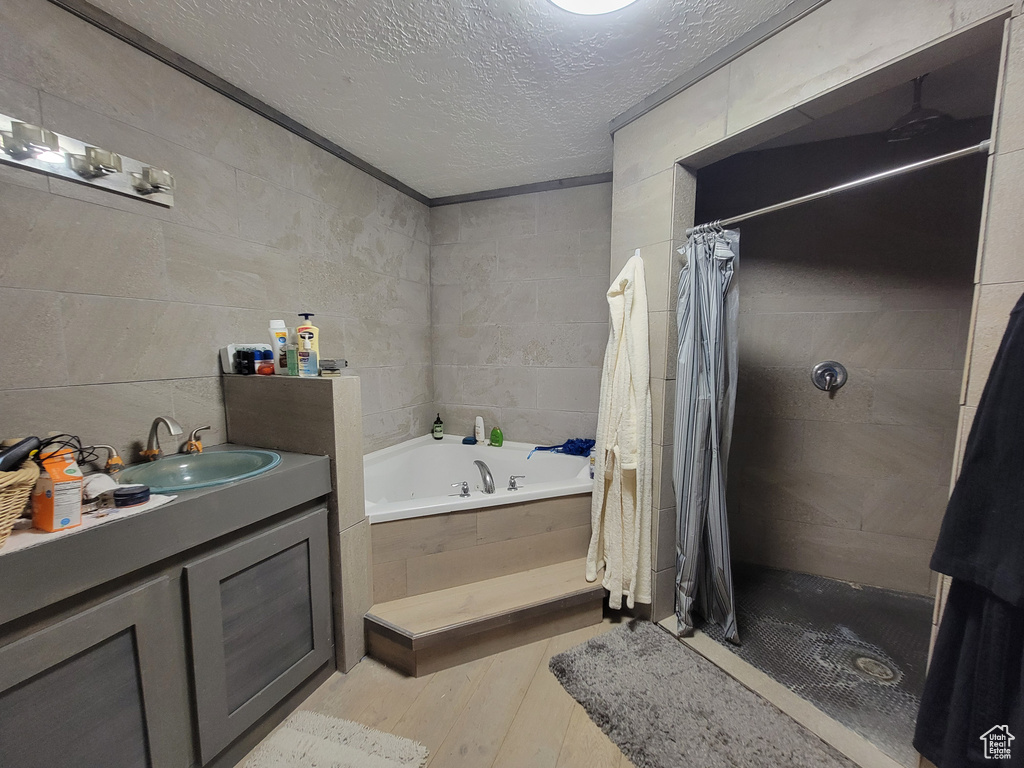 Bathroom featuring a shower with curtain, vanity, tile walls, and a textured ceiling
