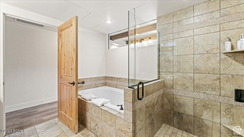 Bathroom featuring tile floors and separate shower and tub