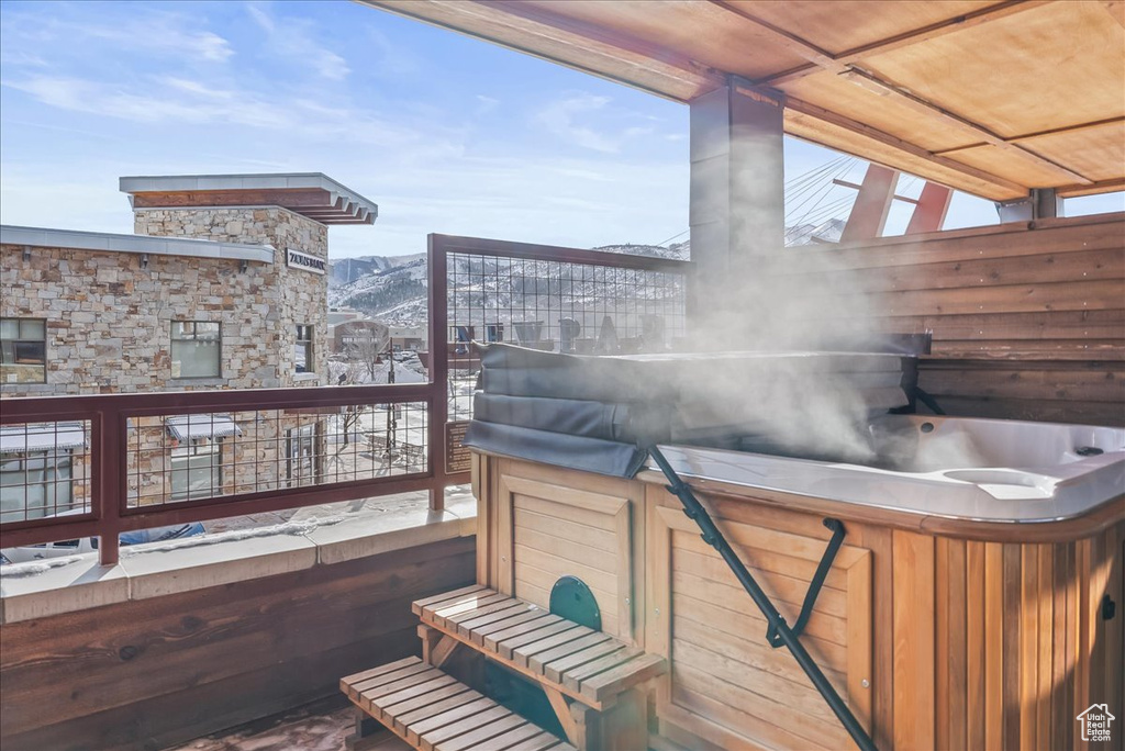 Deck with a mountain view and a hot tub
