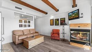 Living room with dark hardwood / wood-style flooring and beamed ceiling