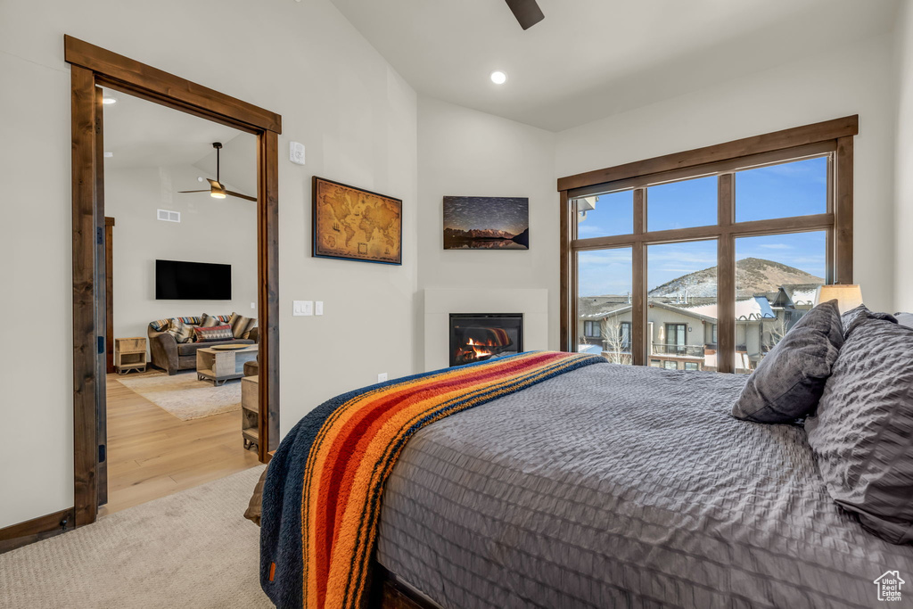 Bedroom with access to exterior, high vaulted ceiling, light colored carpet, and ceiling fan
