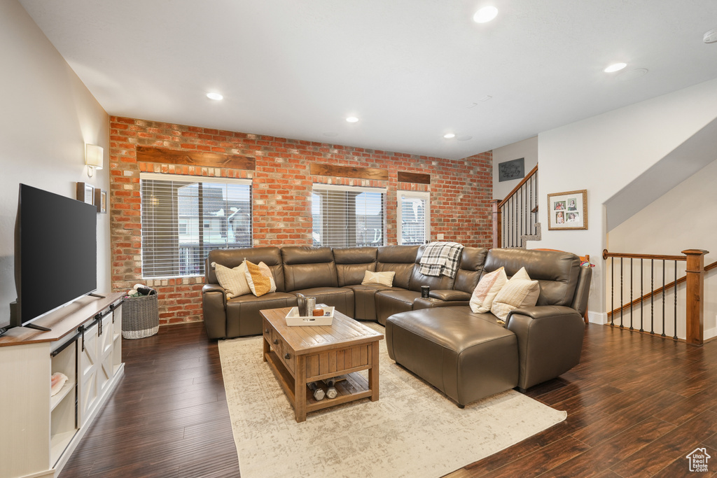 Living room featuring dark hardwood / wood-style flooring and brick wall