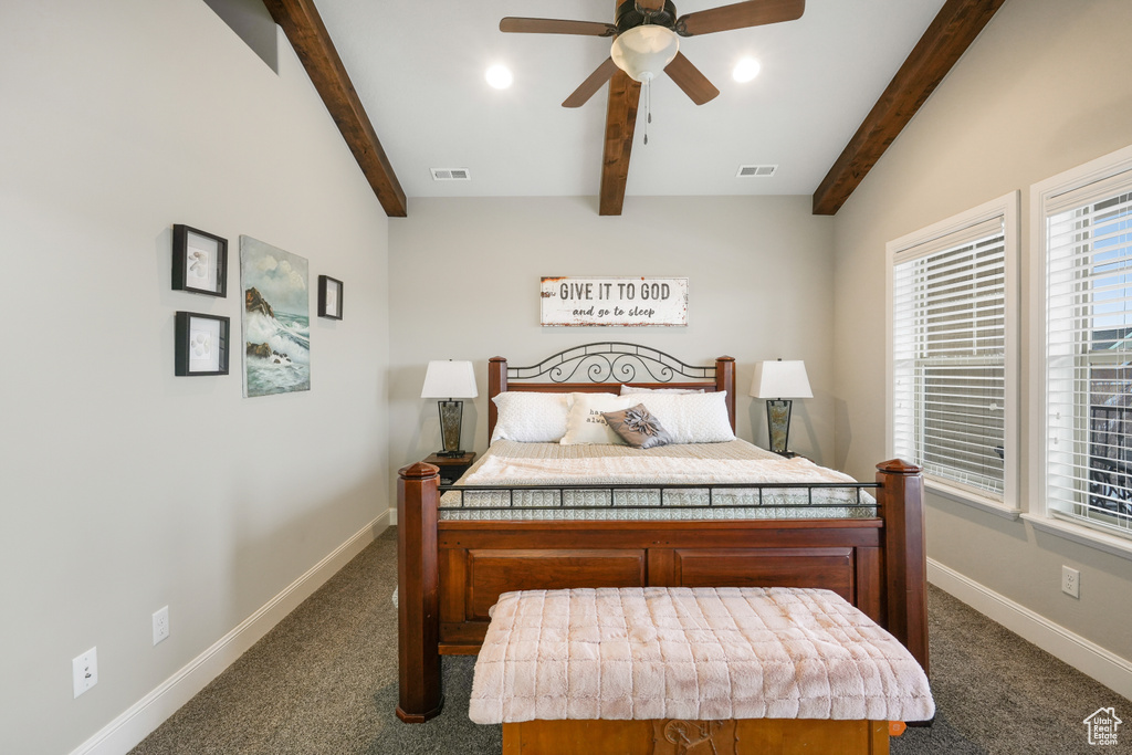 Carpeted bedroom featuring beamed ceiling and ceiling fan