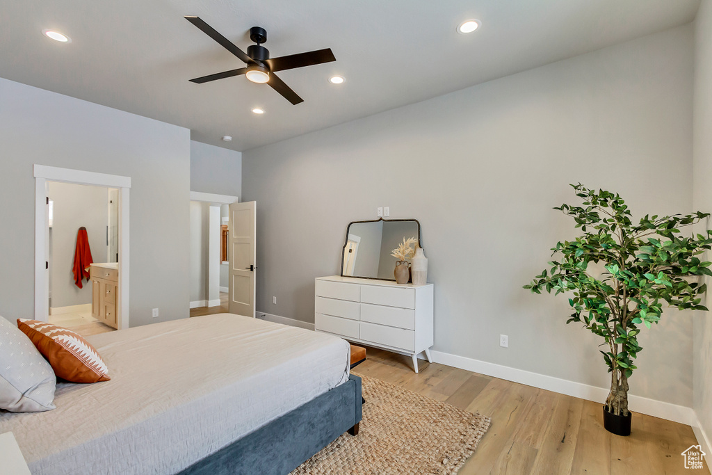 Bedroom with light hardwood / wood-style flooring, connected bathroom, and ceiling fan