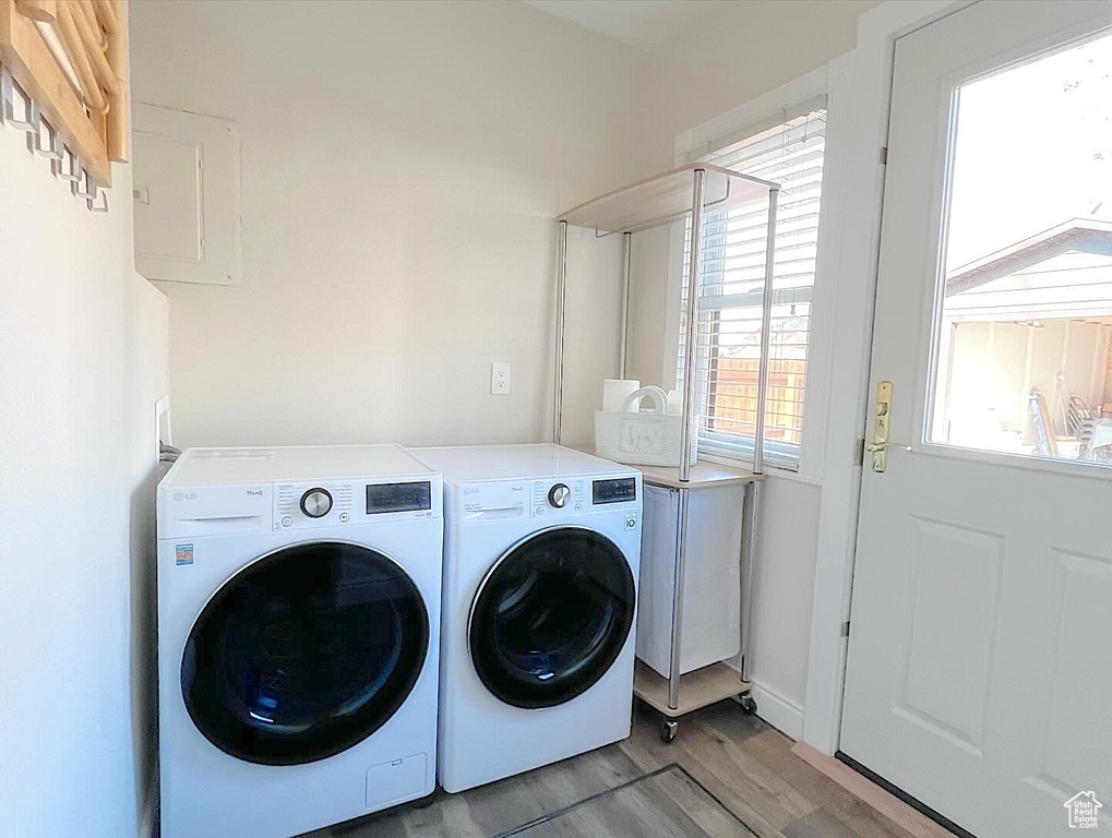 Laundry room featuring washing machine and clothes dryer and light hardwood / wood-style floors