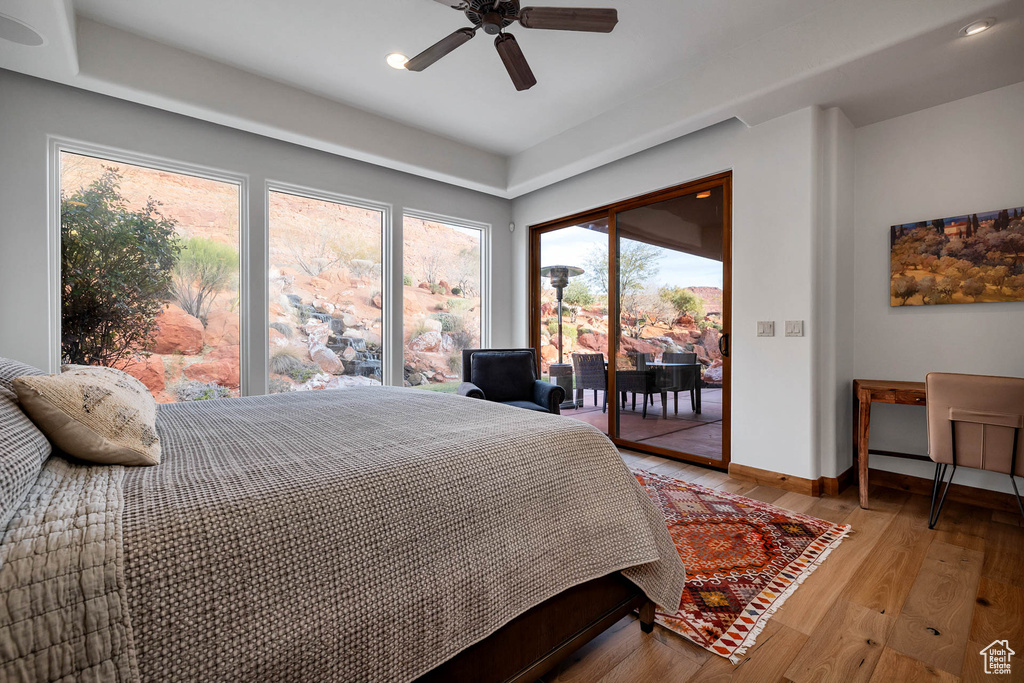 Bedroom with light hardwood / wood-style floors, access to exterior, and ceiling fan