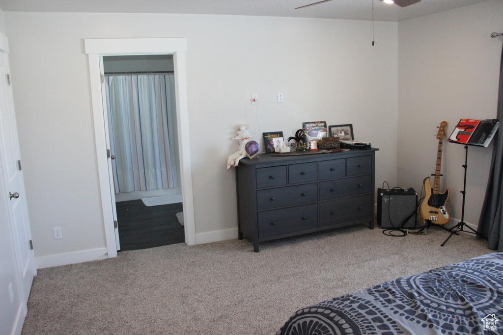 Bedroom with ensuite bath, light colored carpet, and ceiling fan