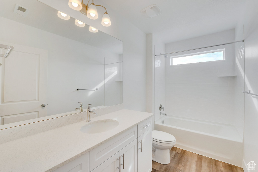 Full bathroom featuring vanity, toilet, bathtub / shower combination, and hardwood / wood-style flooring