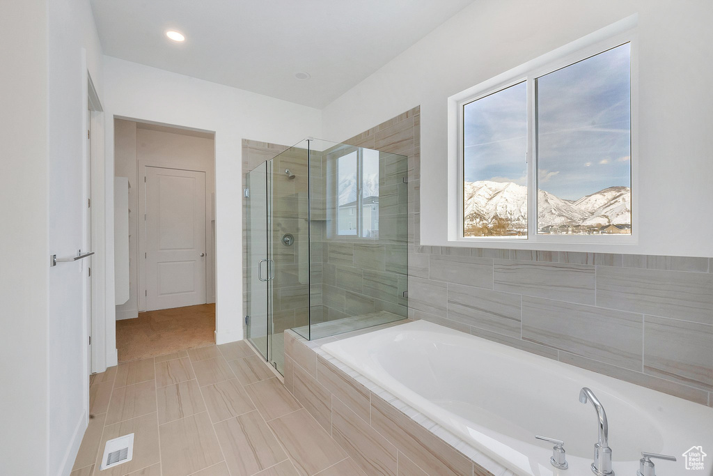Bathroom with tile floors, independent shower and bath, and a mountain view