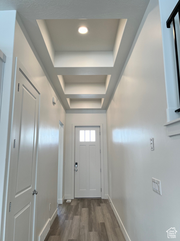 Doorway to outside featuring dark hardwood / wood-style flooring and a tray ceiling