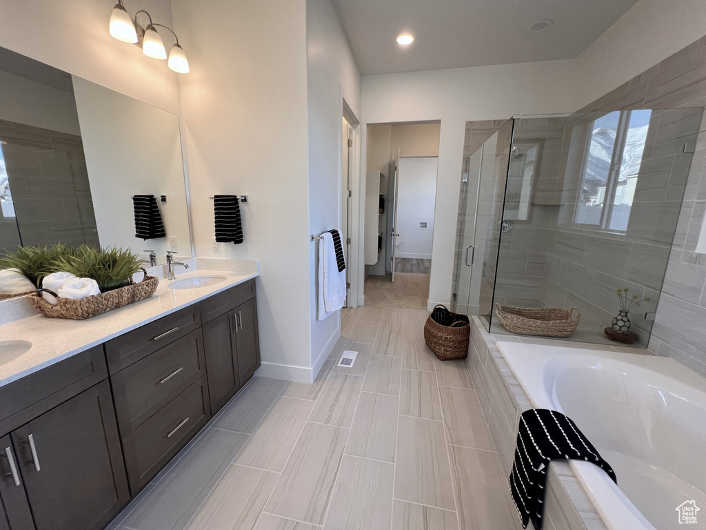 Bathroom with separate shower and tub, double vanity, and tile flooring