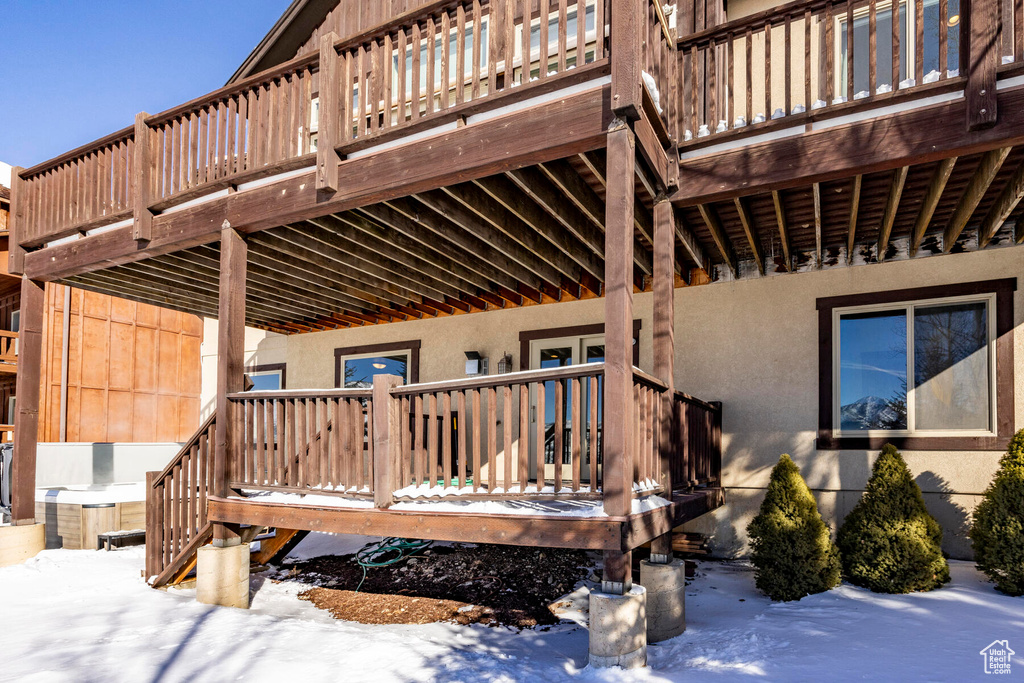 Snow covered property entrance featuring a deck